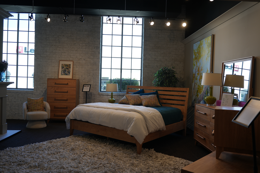 Lifestyle bedroom set showroom display with bed dresser mirror and nightstand