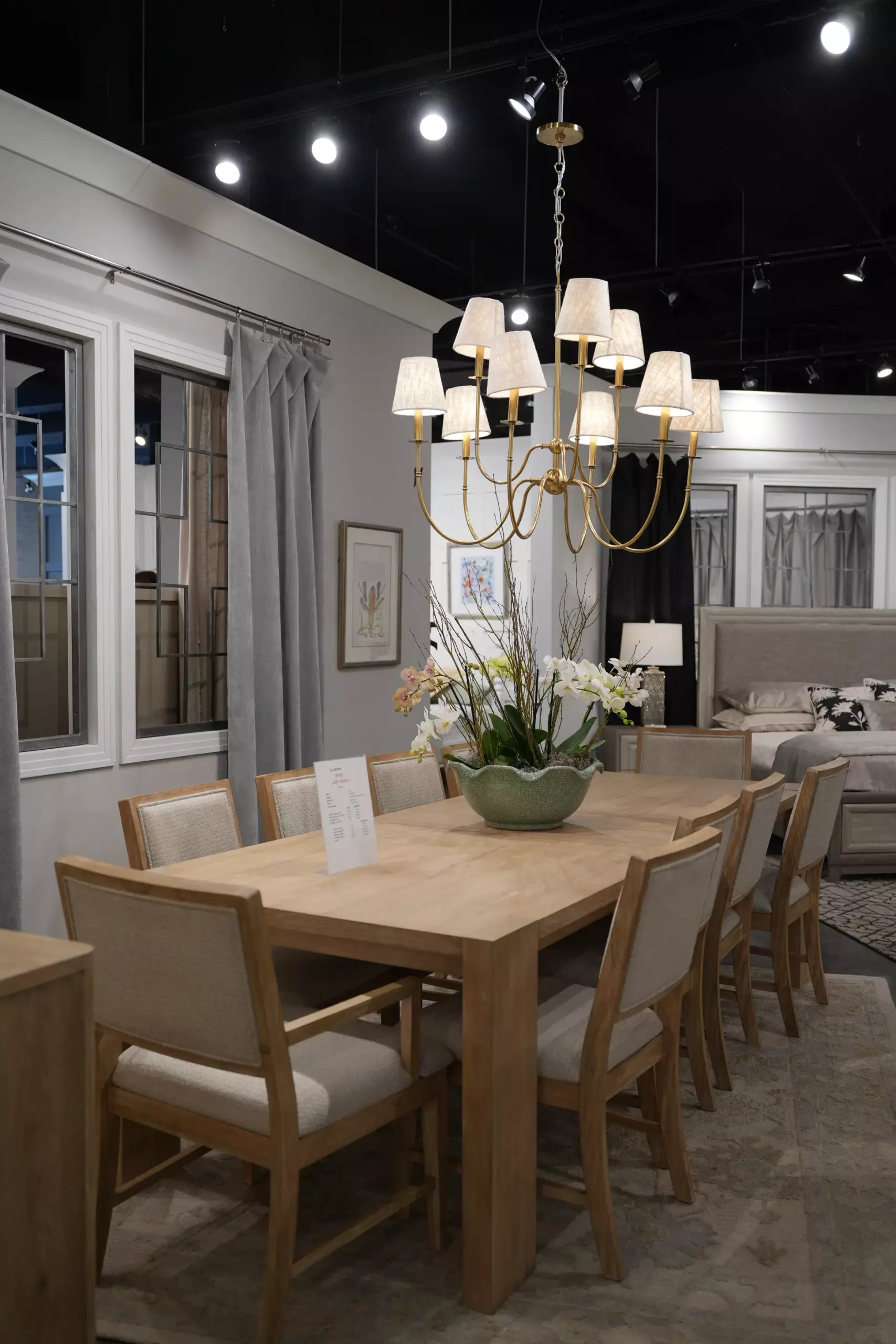 Wholesale dining furniture supplier showroom display with light wood dining table and upholstered chairs