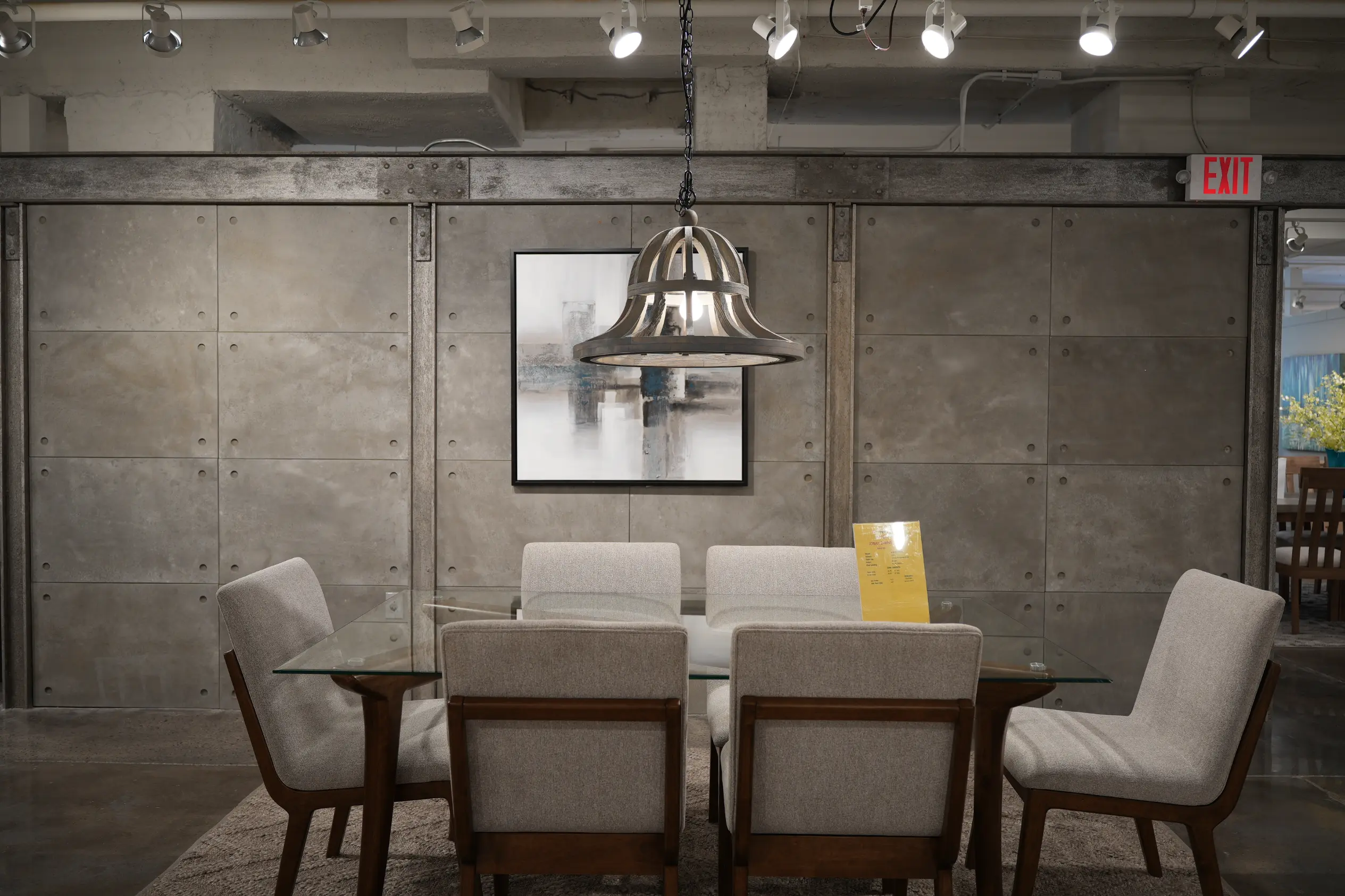 Glass dining table with wood-frame upholstered chairs at Lifestyle showroom